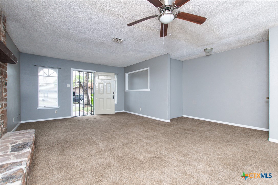 1520 McCarthy Avenue Killeen, TX 76549 - Photo 4 of 23 an empty room with chandelier fan and windows