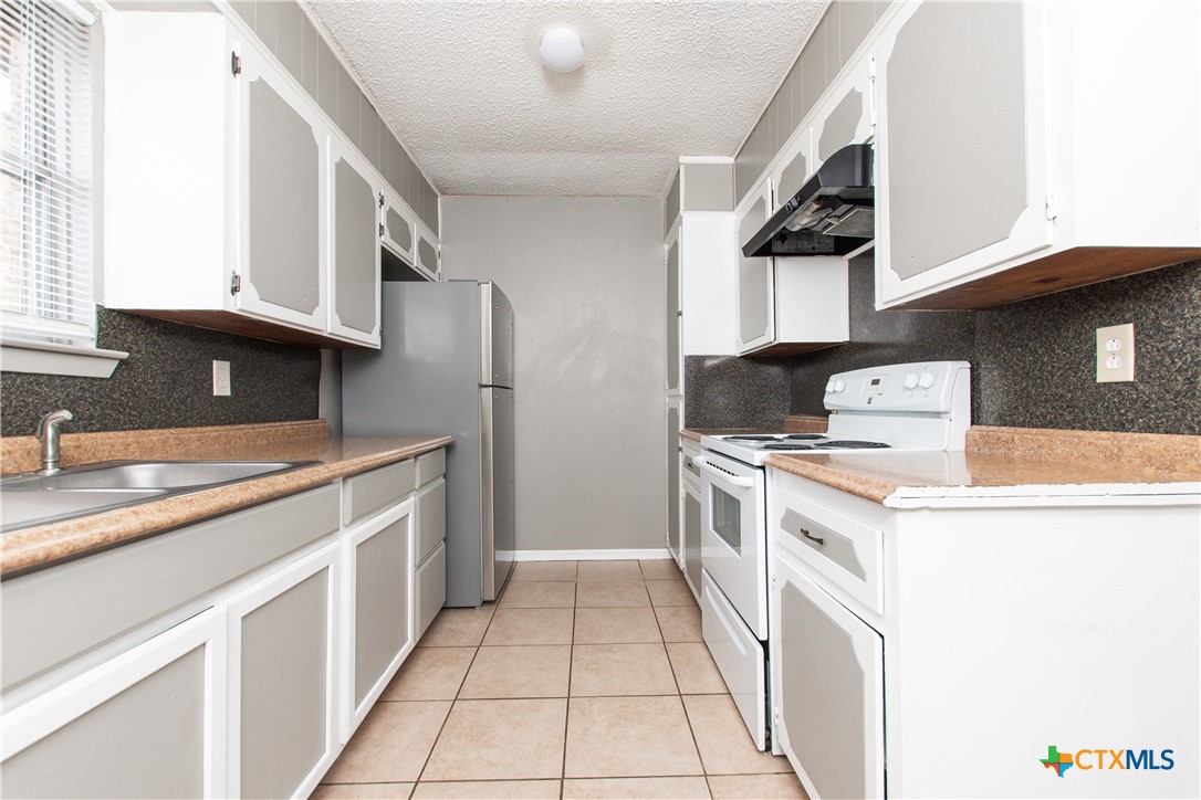1520 McCarthy Avenue Killeen, TX 76549 - Photo 8 of 23 a kitchen with a stove sink and cabinets