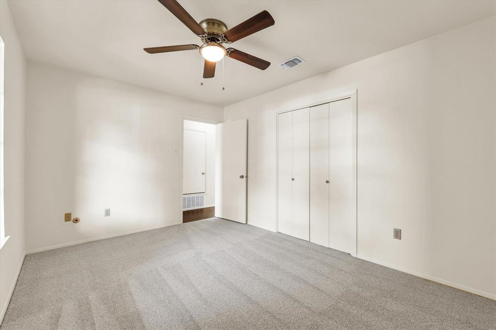 141 Travis Lane Hewitt, TX 76643 - Photo 16 of 31 Carpeted interior room featuring a ceiling fan with integrated lighting, bi-fold closet doors, and white painted walls