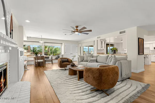 a living room with furniture a fireplace and wooden floor