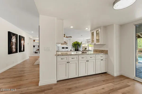 a large kitchen with kitchen island white cabinets and stainless steel appliances