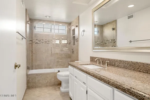 a view of a kitchen island with kitchen island a sink stainless steel appliances and cabinets