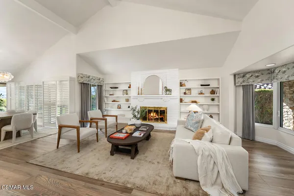 a living room with furniture fireplace and a large window