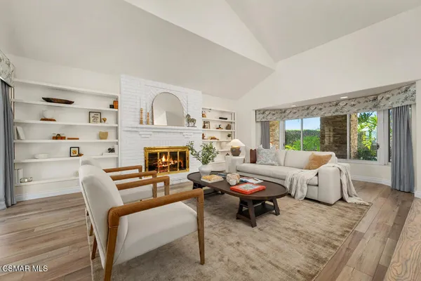 a living room with fireplace furniture and a table
