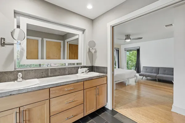 a spacious bathroom with a granite countertop sink mirror and bathtub