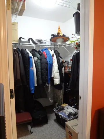 a view of walk in closet with clothes and shoes