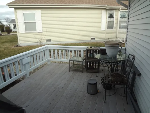 a view of a patio with couches chairs potted plants and wooden floor