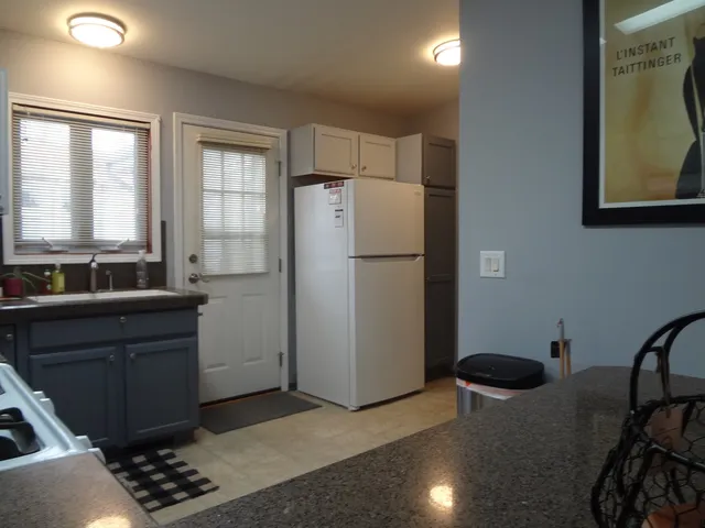 a kitchen with stainless steel appliances granite countertop a refrigerator a sink and a stove