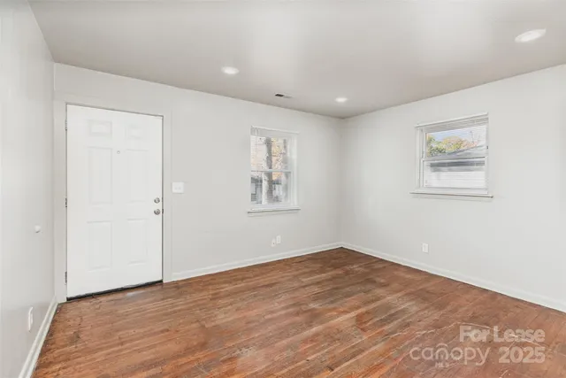 a view of empty room with wooden floor