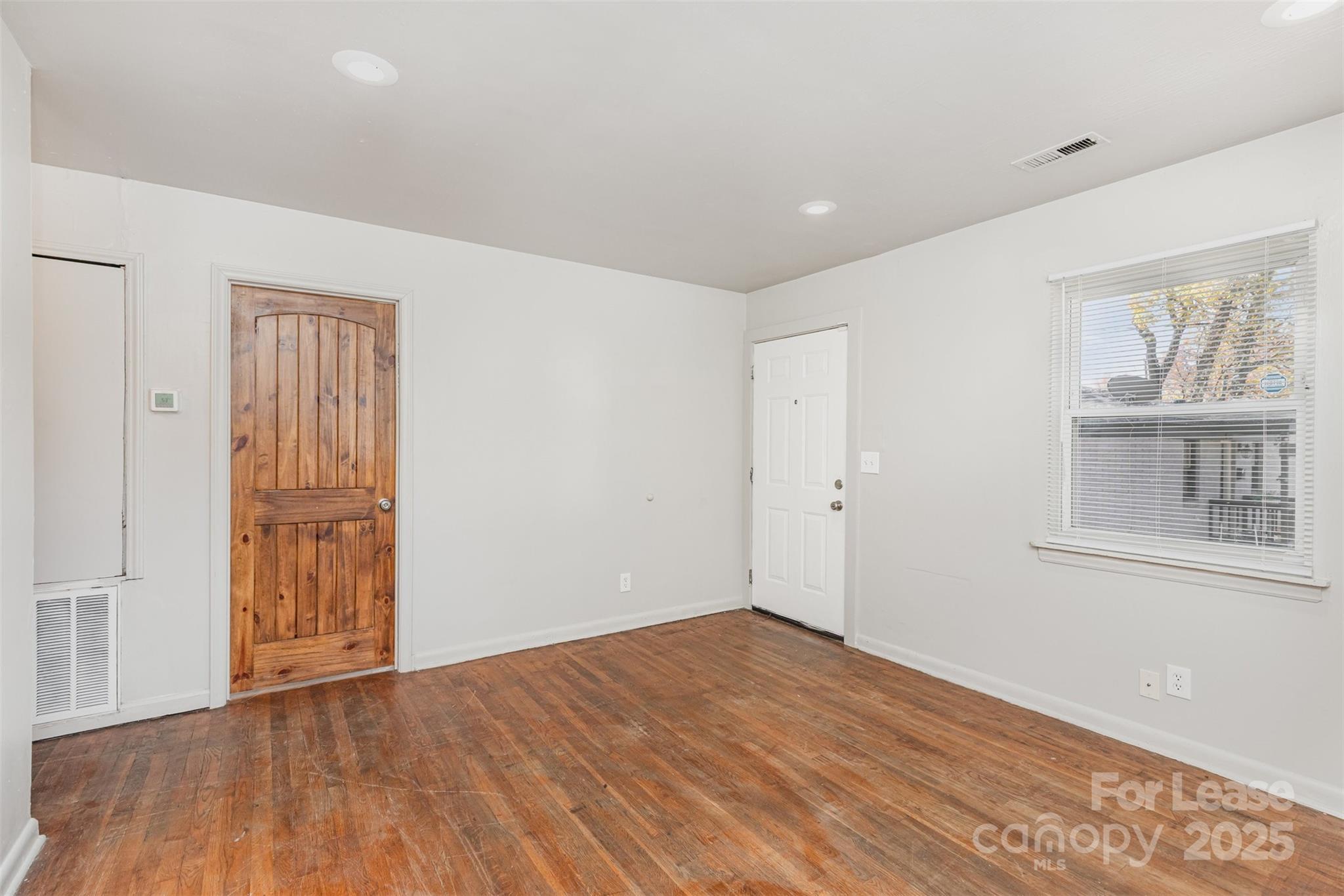2317 Julia Avenue, Unit 3 Charlotte, NC 28206 - Photo 5 of 12 a view of an empty room with wooden floor and a window