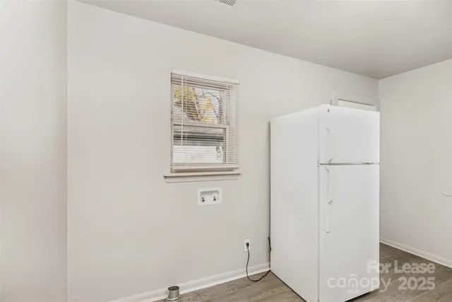 a view of a livingroom with wooden floor and a window