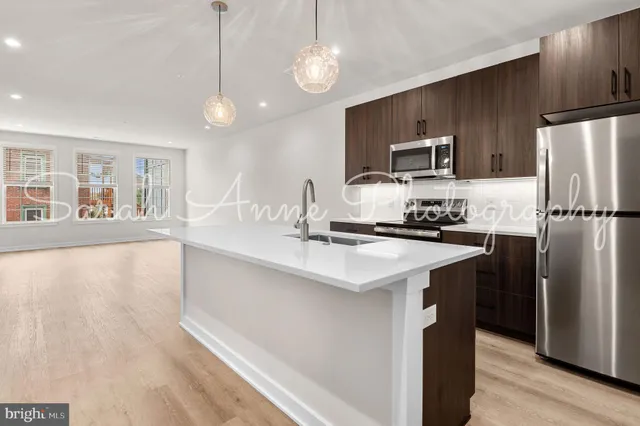 a kitchen with kitchen island a counter top space stainless steel appliances and cabinets