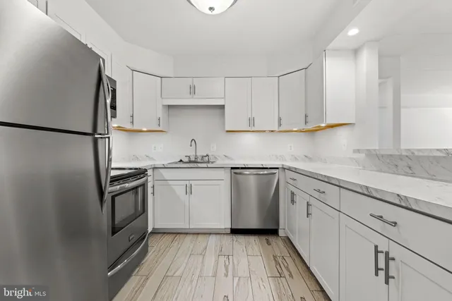 a kitchen with granite countertop white cabinets and white appliances