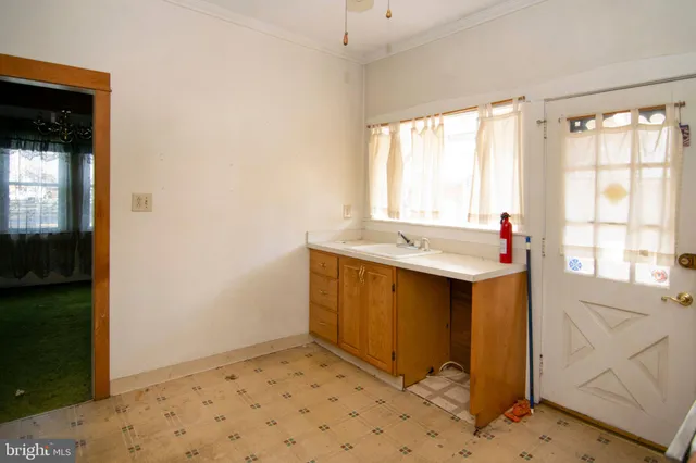 a view of a hallway with wooden floor and a refrigerator