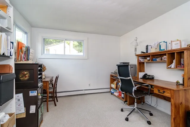 a view of a workspace with furniture and a window