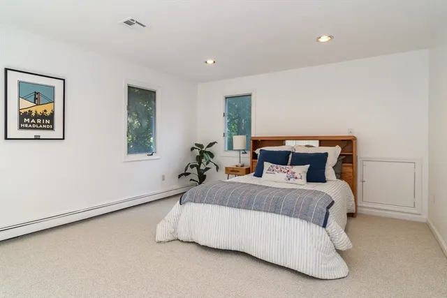 a bedroom with a bed and painting on the wall