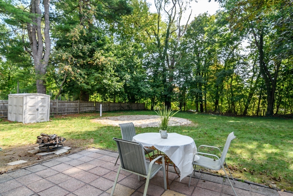 9 Liberty Street Natick, MA 01760 - Photo 23 of 27 a view of a backyard with table and chairs potted plants and large tree