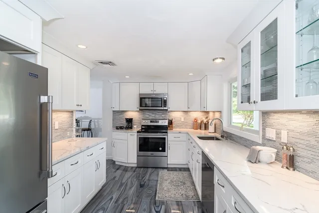 a kitchen with stainless steel appliances granite countertop a refrigerator sink and stove