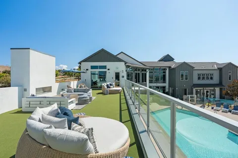 a view of a house with backyard sitting area and swimming pool