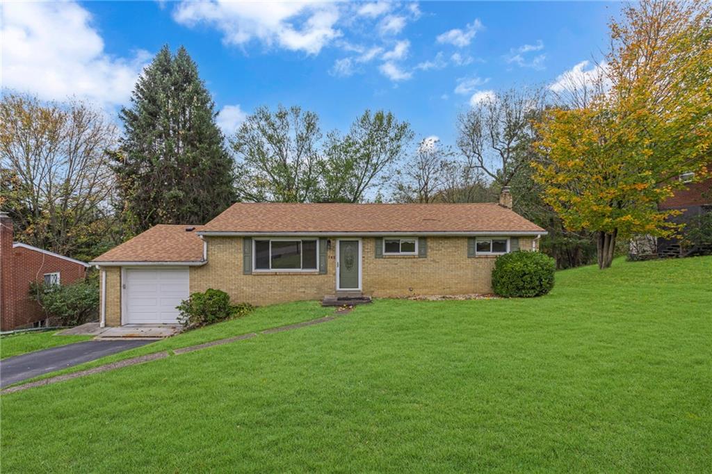a view of a house with a big yard potted plants and large tree