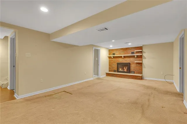 a view of an empty room with a fireplace and a window