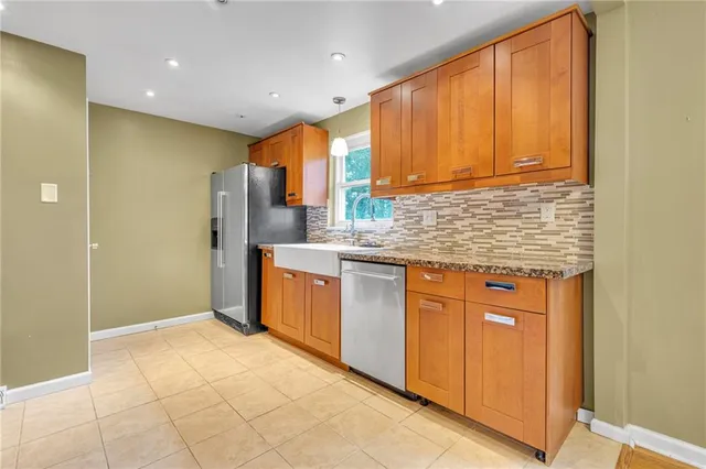 a kitchen with stainless steel appliances granite countertop a refrigerator and a sink