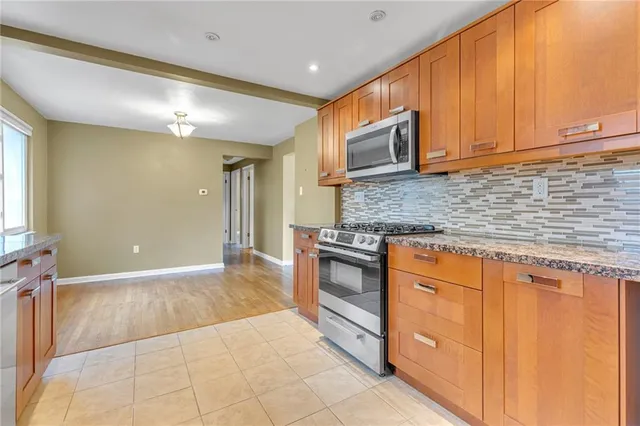 a kitchen with stainless steel appliances granite countertop a sink stove and cabinets