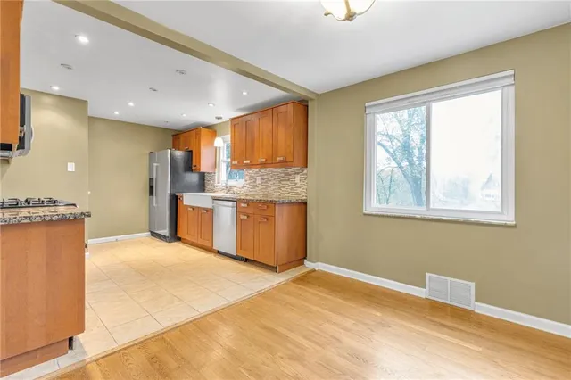 a kitchen with stainless steel appliances granite countertop a refrigerator a sink dishwasher and a stove