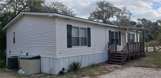 a view of a house with a yard and wooden fence