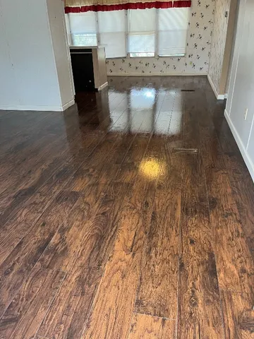 a view of empty room with wooden floor