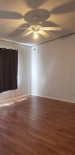 732 Hidden Oaks Drive Elgin, TX 78621 - Photo 4 of 9 Unfurnished room featuring wood finished floors and a ceiling fan