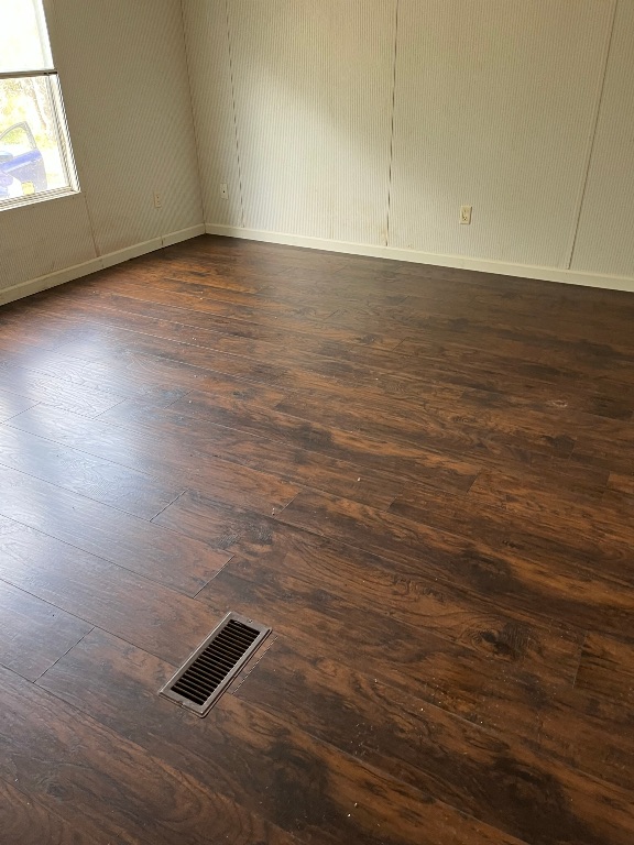 732 Hidden Oaks Drive Elgin, TX 78621 - Photo 7 of 9 Unfurnished room featuring dark wood-type flooring and baseboards