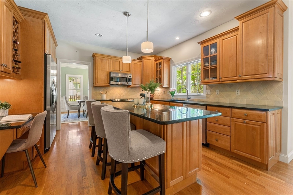 33 Bond Street Needham, MA 02492 - Photo 11 of 35 a kitchen with stainless steel appliances granite countertop a sink a stove a refrigerator dining table and chairs
