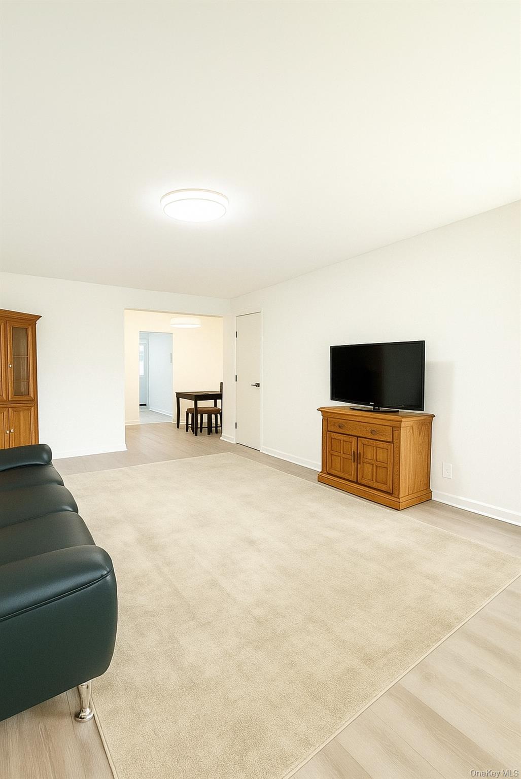 69-09 150th Street, Unit 320A Queens, NY 11367 - Photo 3 of 7 a living room with furniture and a flat screen tv