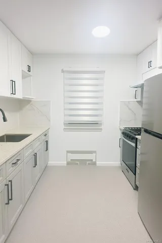 a kitchen with white cabinets and white appliances