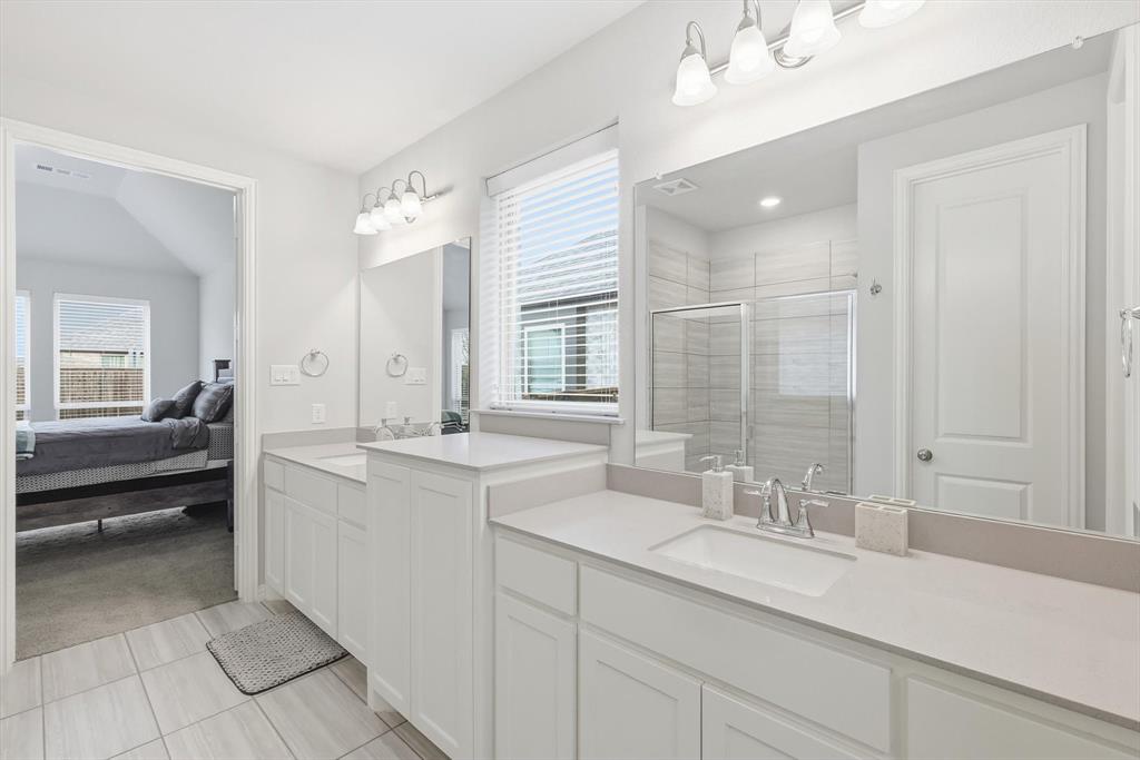 1708 Bird Cherry Lane Prosper, TX 75078 - Photo 16 of 32 a bathroom with a sink double vanity granite tub shower and a mirror