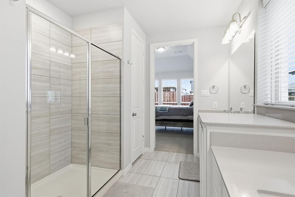 1708 Bird Cherry Lane Prosper, TX 75078 - Photo 17 of 32 a en suite bathroom with a shower a sink and a mirror