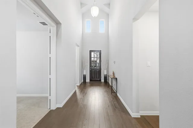 a view of a hallway with wooden floor