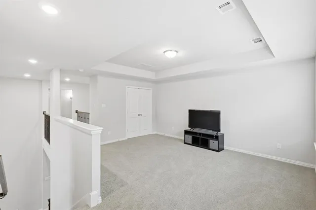 a view of a room with a refrigerator and a flat screen tv