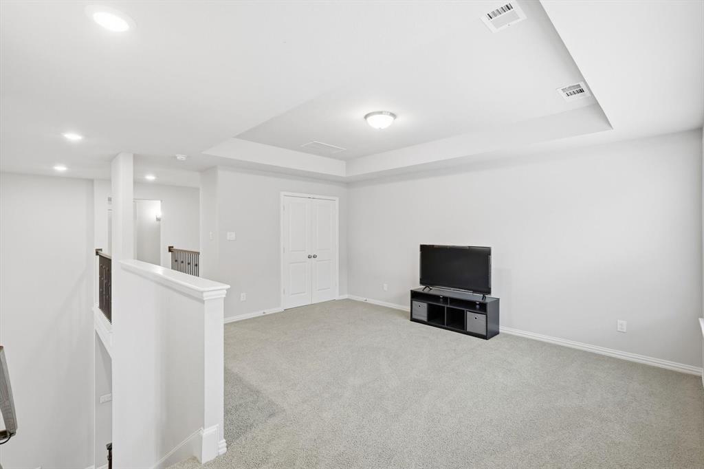 1708 Bird Cherry Lane Prosper, TX 75078 - Photo 24 of 32 a view of a room with a refrigerator and a flat screen tv