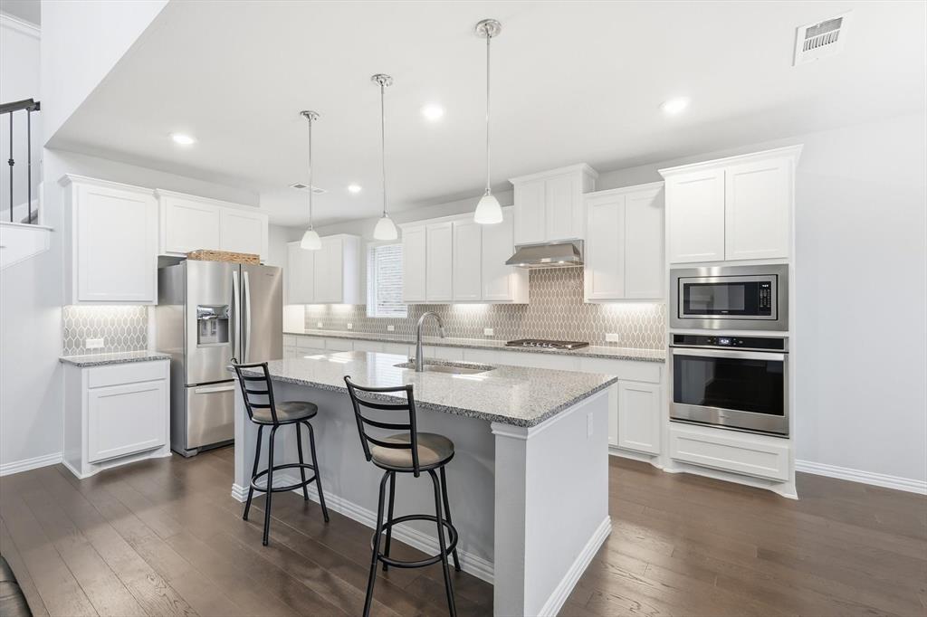 1708 Bird Cherry Lane Prosper, TX 75078 - Photo 4 of 32 a kitchen with a refrigerator a stove a sink and chairs