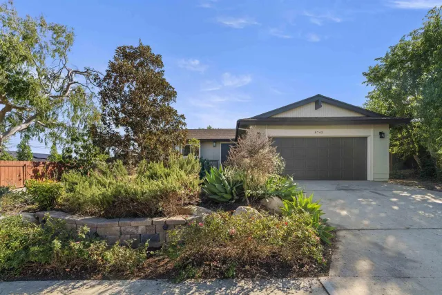 a front view of a house with a garden