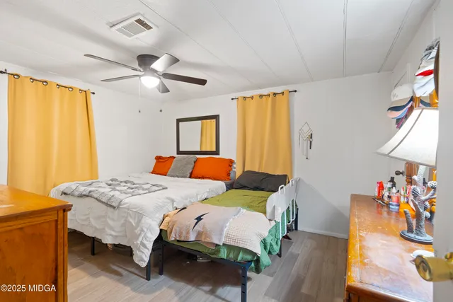 a bedroom with a bed and wooden floor