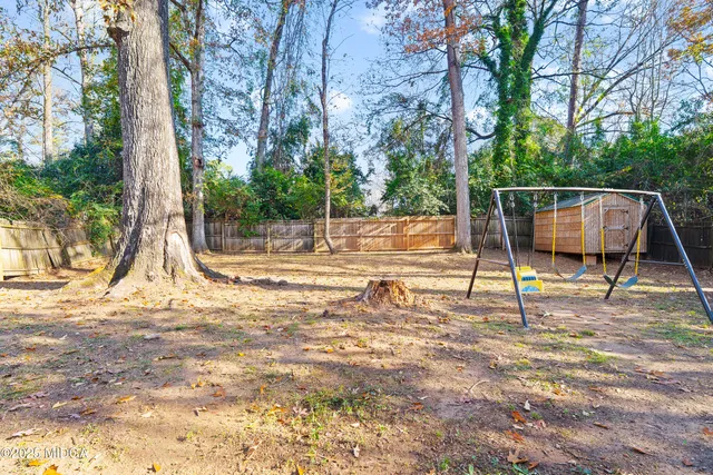 a view of a house with a yard and trees