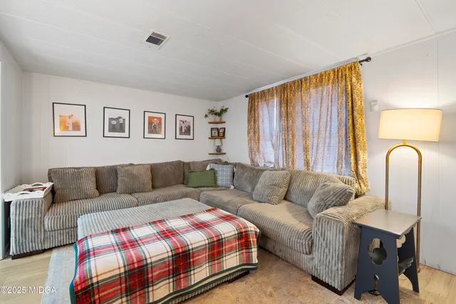 a kitchen with stainless steel appliances a stove a sink a refrigerator white cabinets and wooden floor