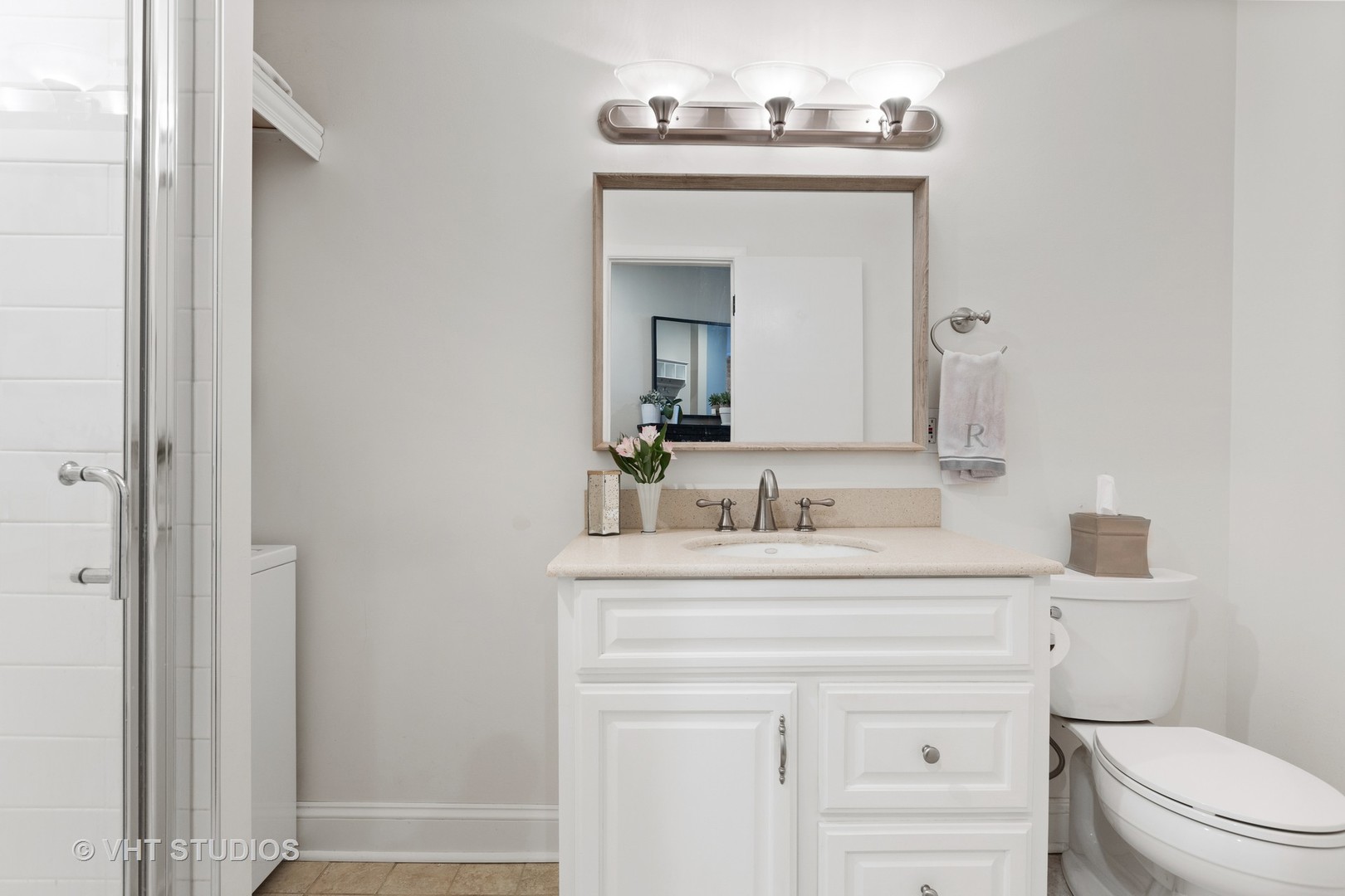 2956 North Halsted Street, Unit 2 Chicago, IL 60657 - Photo 8 of 13 a bathroom with a toilet a sink a vanity and mirror