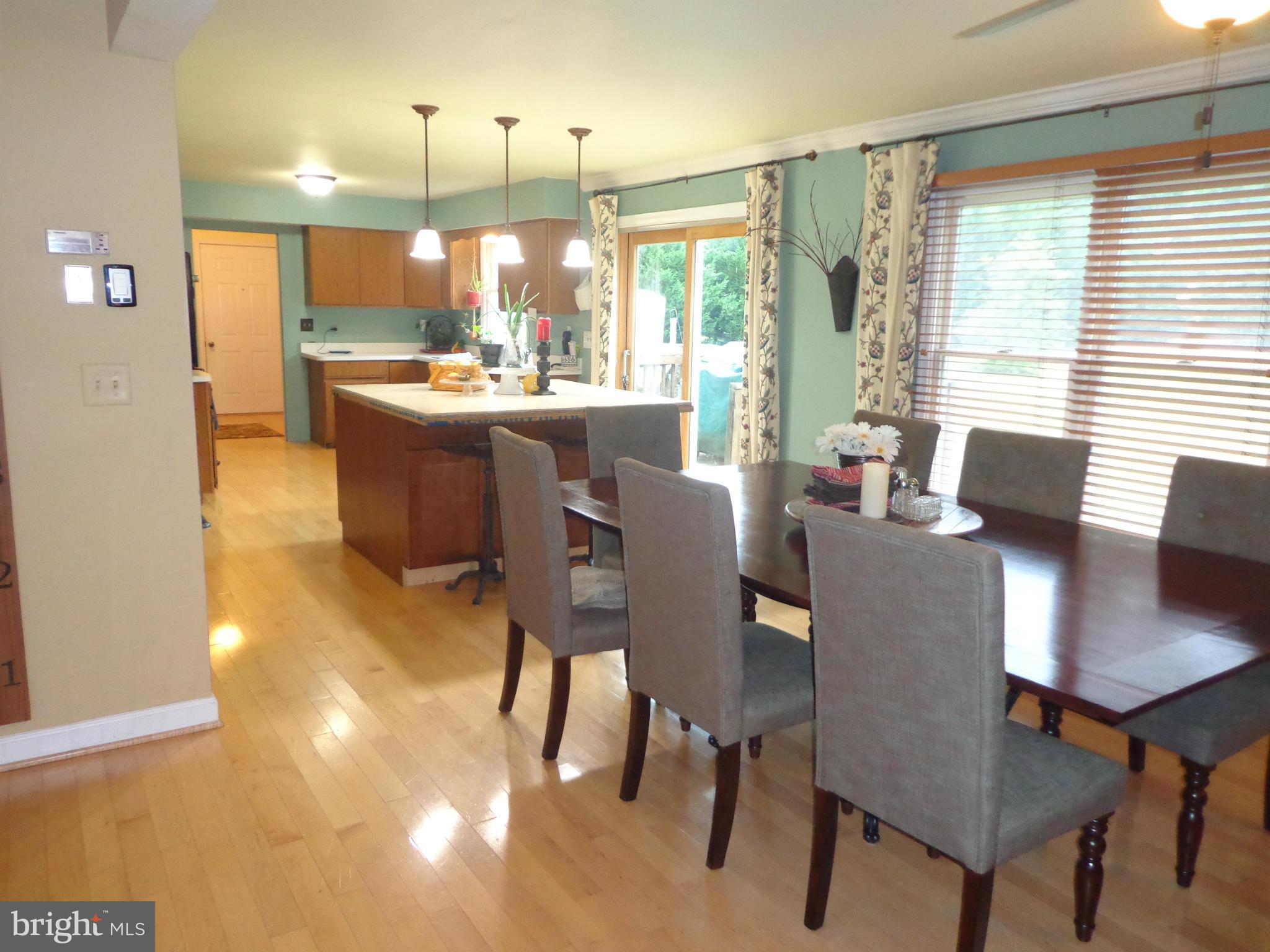 9323 Settle School Road Rixeyville, VA 22737 - Photo 8 of 30 a dining room with kitchen island furniture a window and a kitchen view