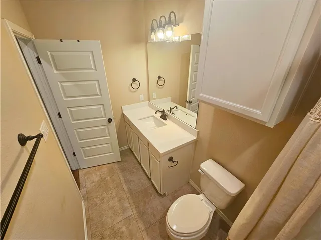 a bathroom with a sink a toilet a mirror and vanity