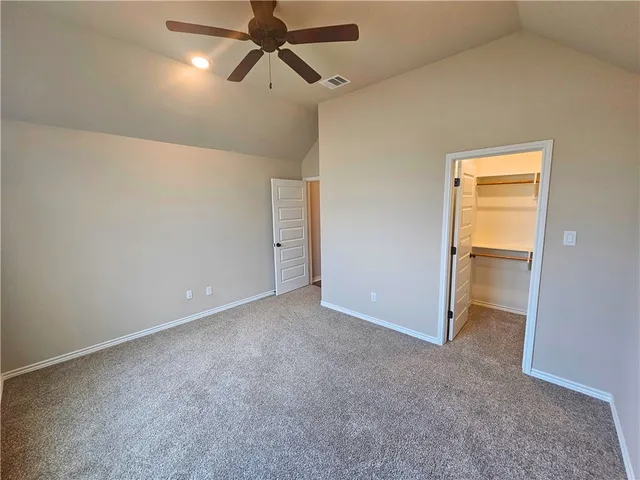 an empty room and chandelier fan
