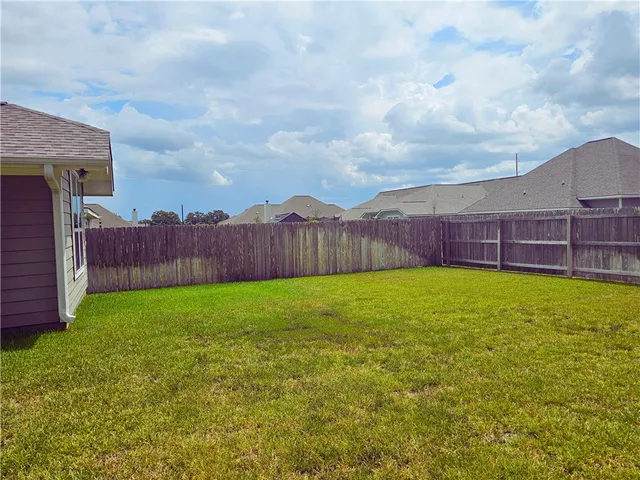 a view of a backyard with wooden fence